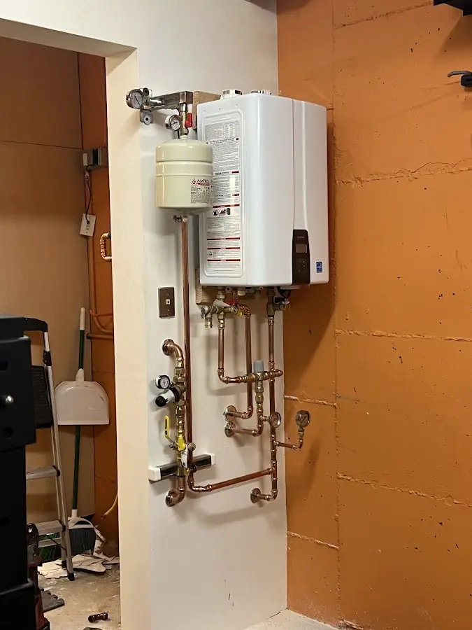 Plumbing technician inspecting water heater connections in Orem